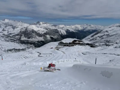 Op een besneeuwde Hintertuxer Gletscher met uitzicht op een pistebully en het dal