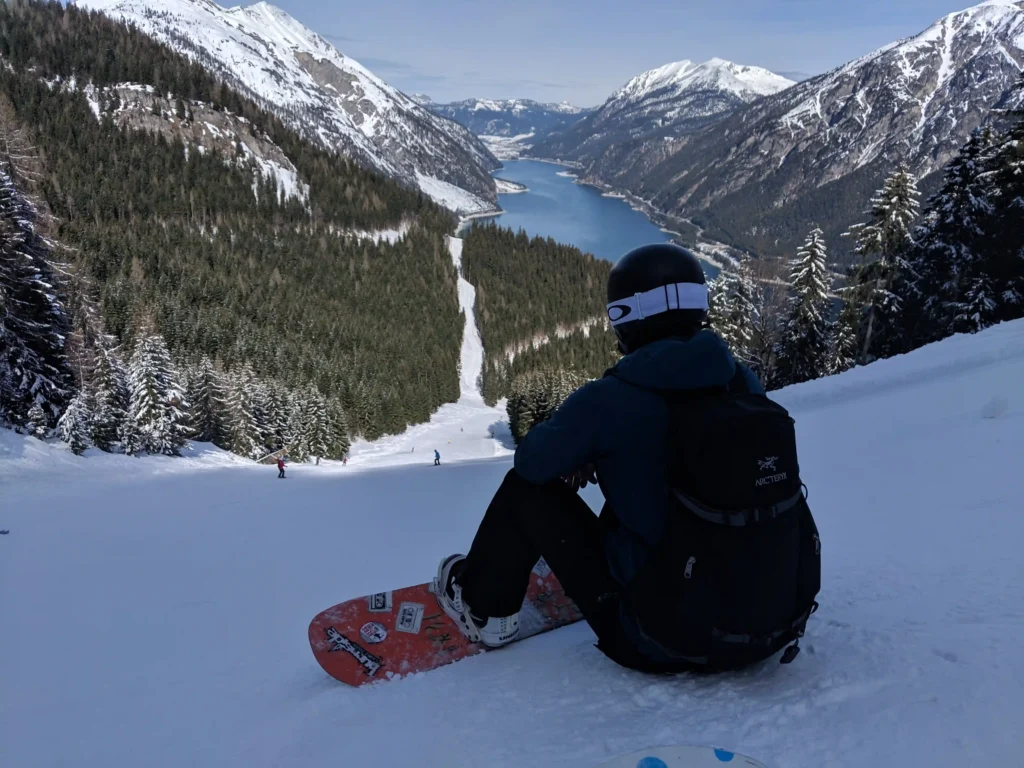 Snowboarder in Karwendel-Pertisau met uitzicht op een piste en de Achensee